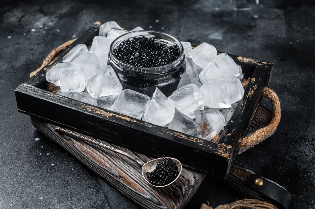 Black caviar in a glass bowl on ice
